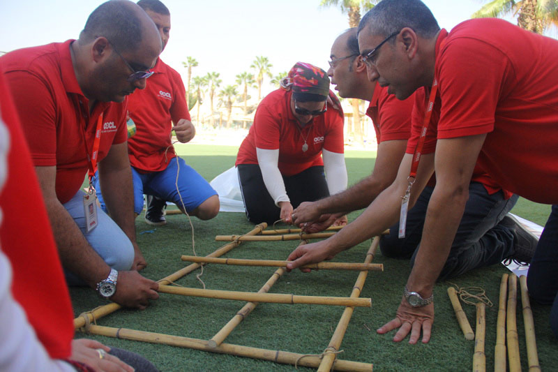 A group of people gathered to play which sticks which inddicates corporate training