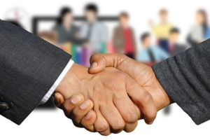 two people shaking hands that indicates negotiation skills
