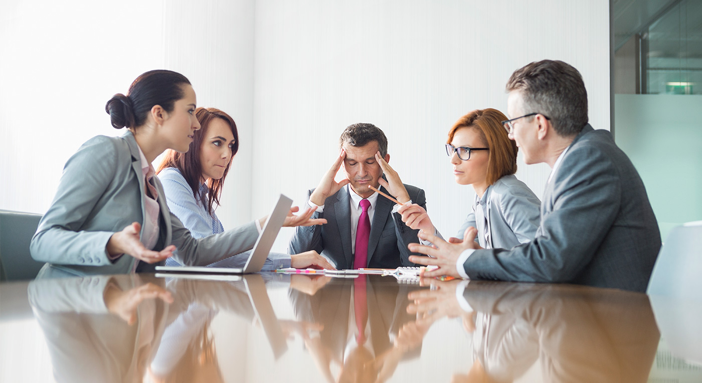A meeting with a group of people sitting together and arguing which indicates conflict management